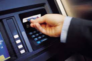 Hand inserting a card into an ATM